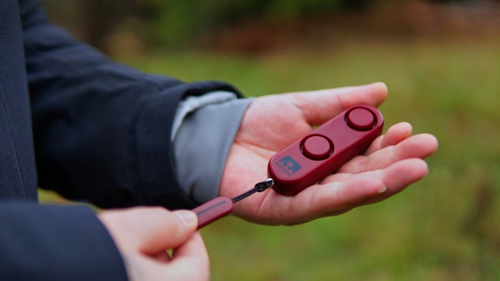 A person holds a red remote control in their hand, ready to use it for a device or entertainment system