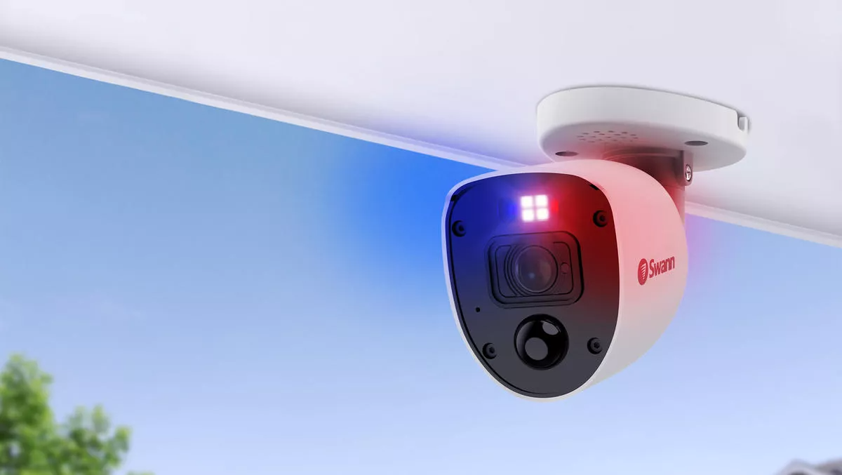 A security camera with flashing red and blue lights, positioned to oversee a public space for safety