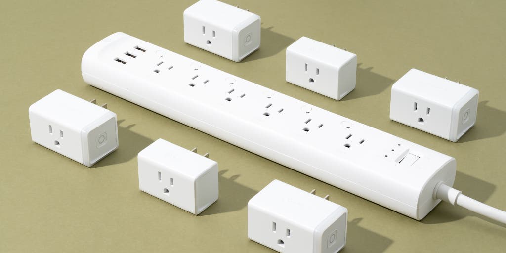 Six white power strips arranged together, with one connected to a wall outlet for power