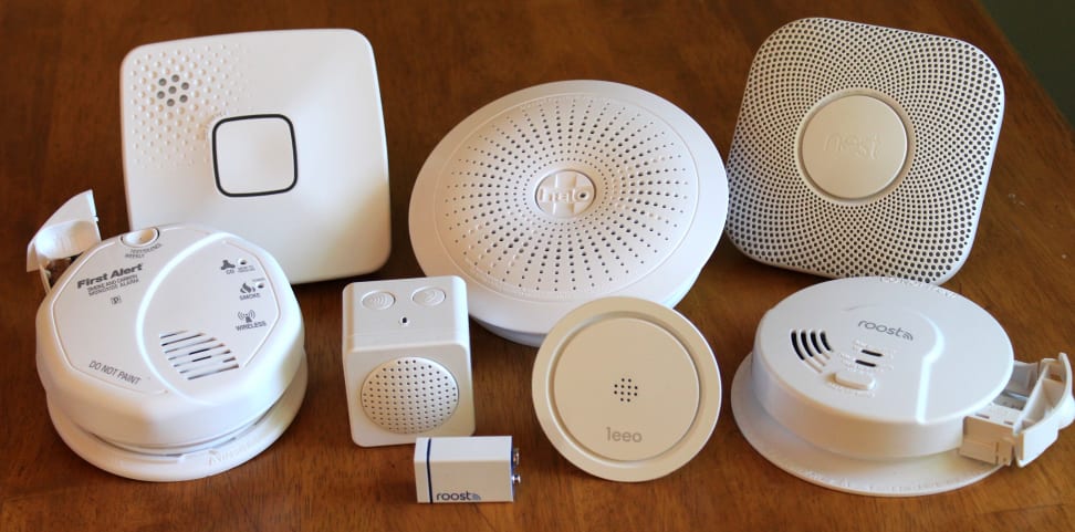 An assortment of smoke alarms alongside different electronic devices arranged for display